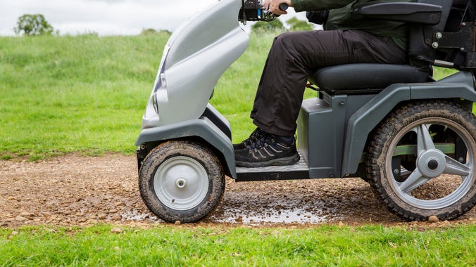 A person's legs as they sit comfortably in a tramper mobility vehicle
